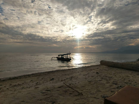 Gili-eilanden - Bewolkte zonsopkomst achter de eenzame vissersboot. Lombok op de achtergrond