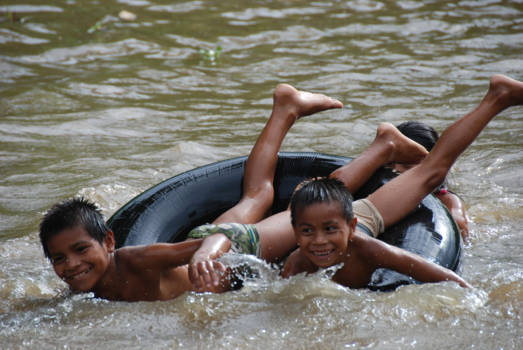 Equator Monument - spelende kids in het water in Equador