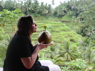Ubud - Drinken uit een kokosnoot met zicht op de rijstvelden